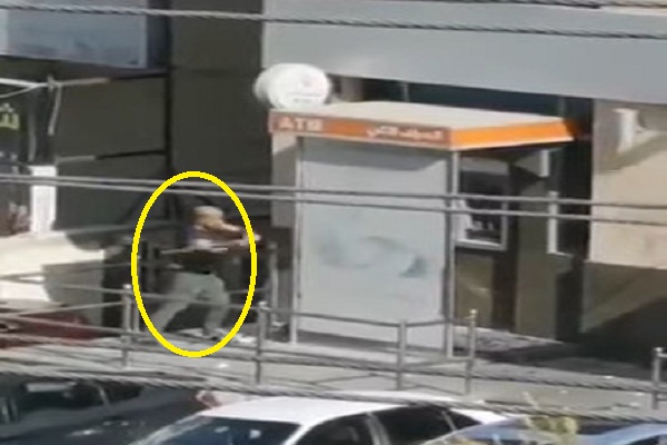 شاهد أردني غاضب يحطم واجهة بنك بالحجارة والعصي.. والكشف عن دوافعه