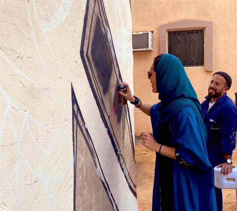 أجمل التجارب.. بالصور: نائبة وزير السياحة تشارك فنانًا عالميًا في رسم جدارية بالعلا